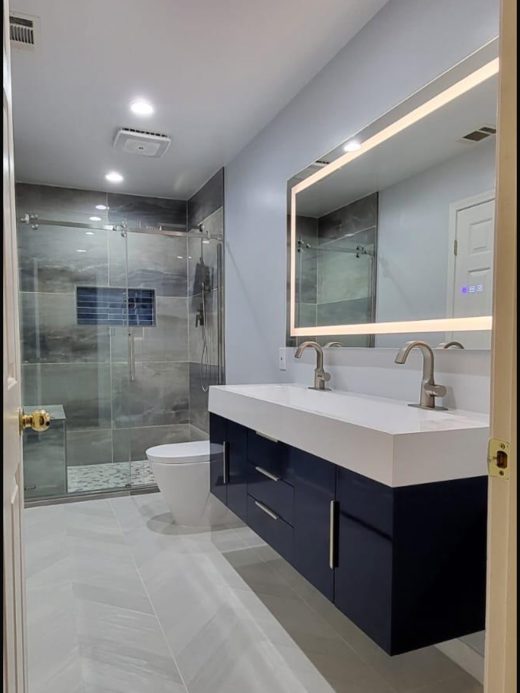 Navy floating vanity with lit mirror